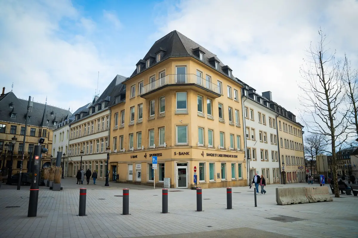 A scenic view of a bustling town square in Luxembourg city, showcasing classic European architecture.