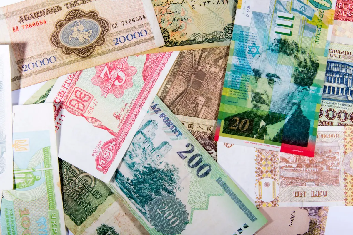 Colorful assortment of international paper currencies from various countries in a flat lay.