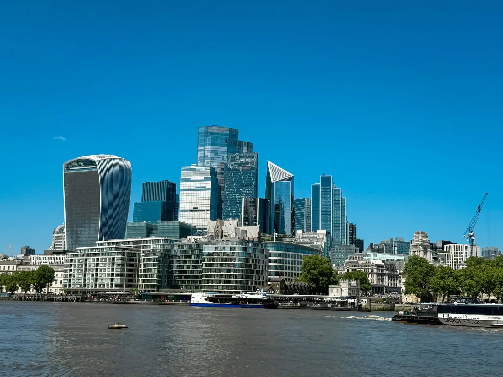 Stunning view of London's modern skyline with iconic skyscrapers by the Thames River.