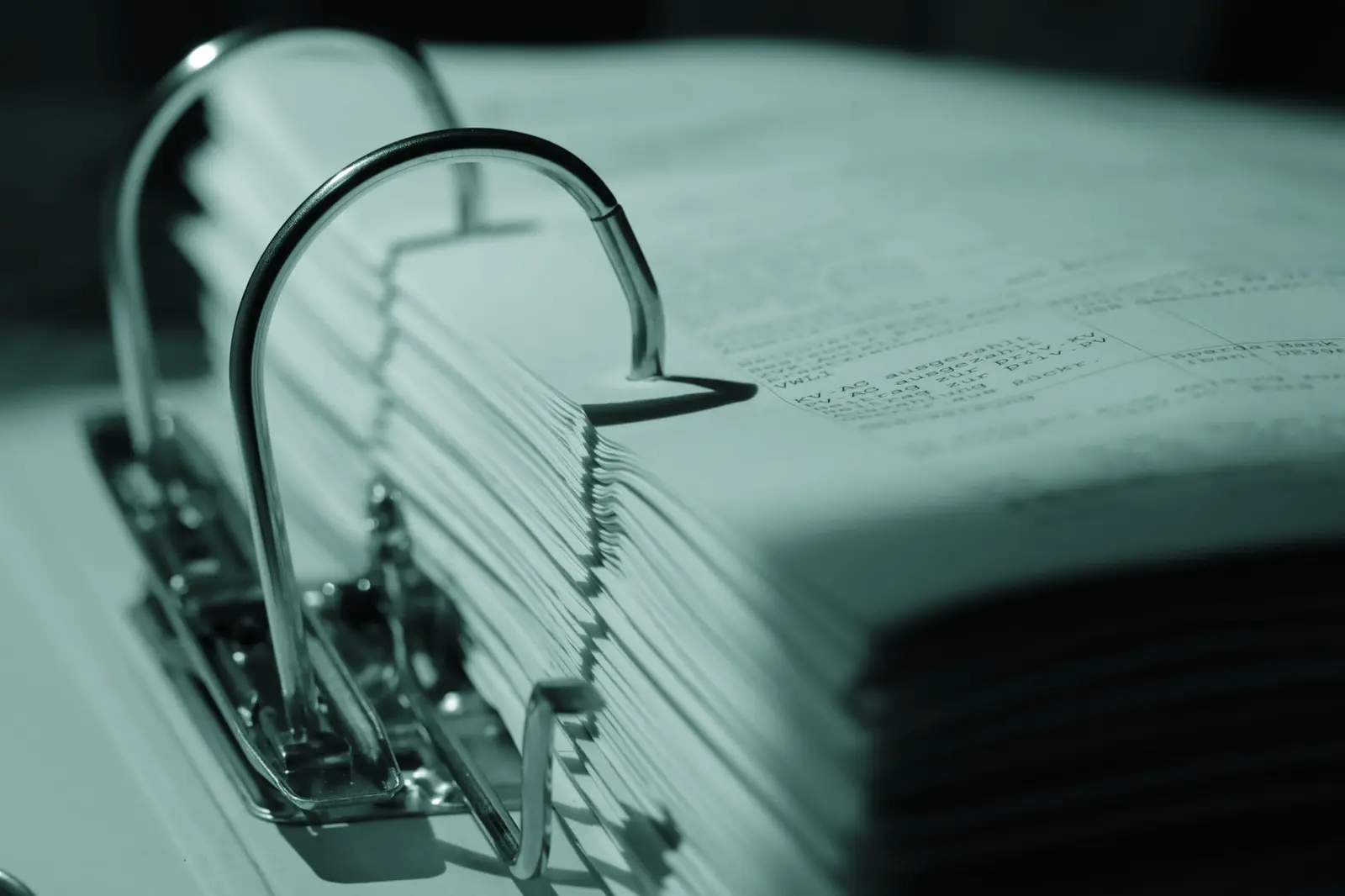 Detailed sepia close-up of a binder filled with documents, emphasizing texture.