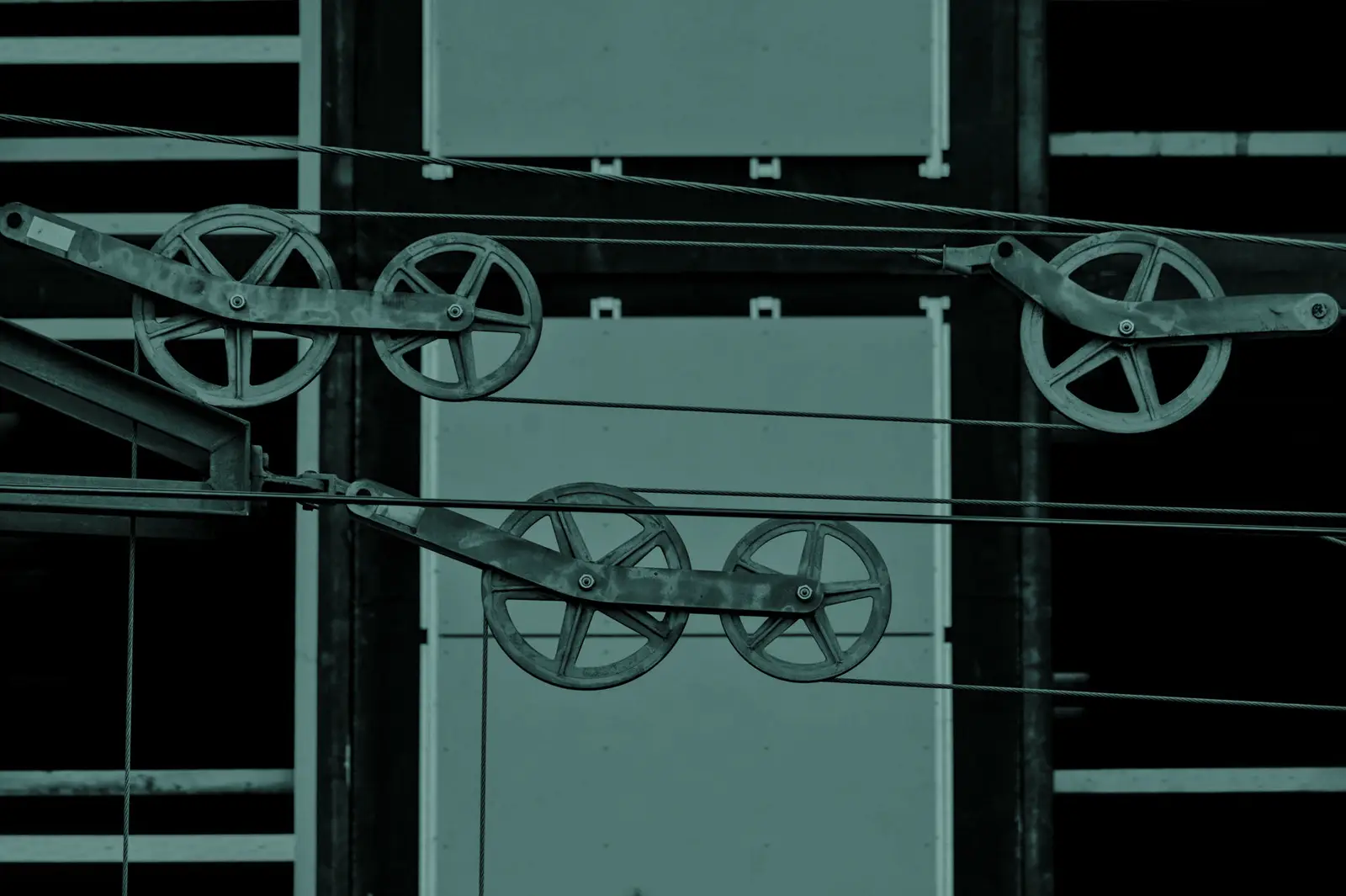 Detailed view of metallic pulleys on a modern building facade, capturing industrial design elements.